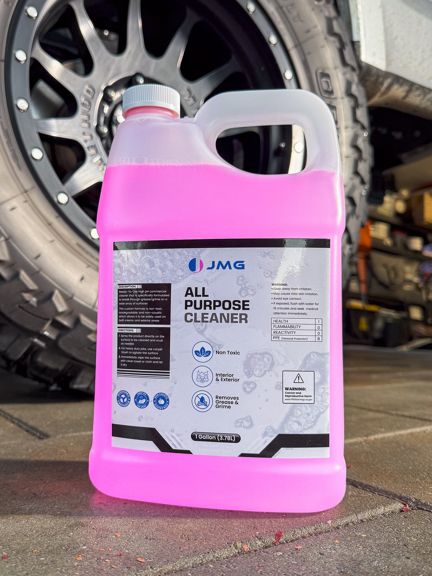 JMG All Purpose Cleaner gallon in front of freshly cleaned truck tire and rim at San Francisco fleet maintenance shop
